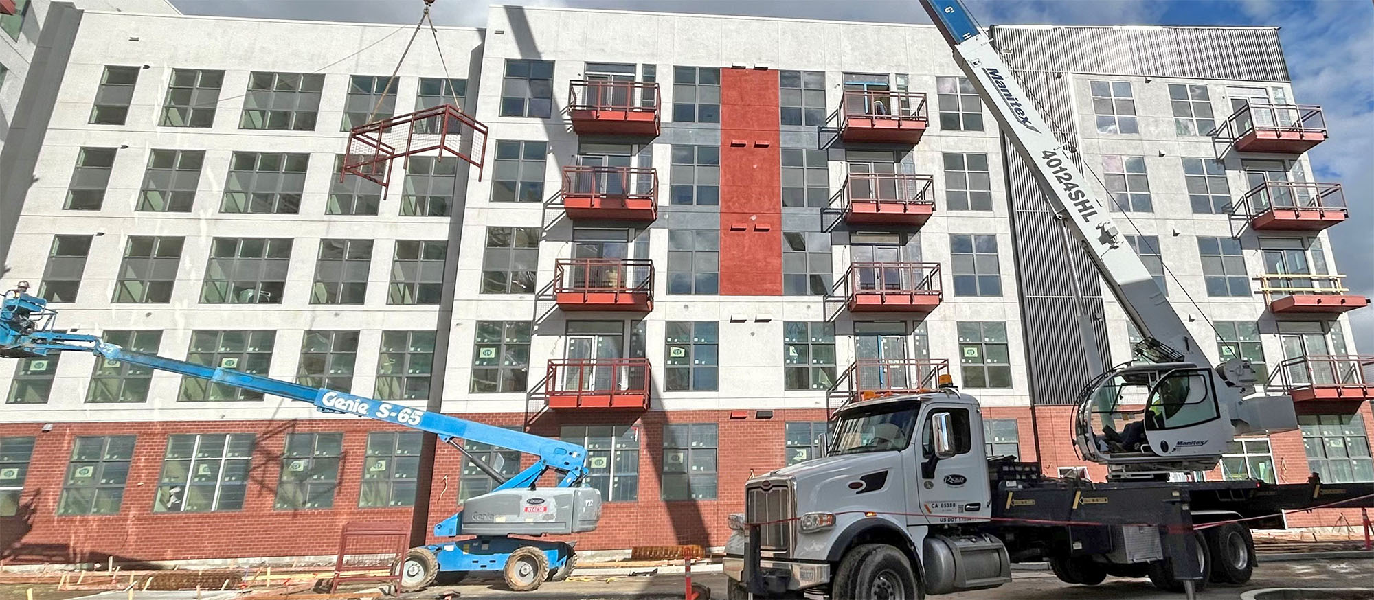 Heavy equipment is parked in front of a large building in the process of being built